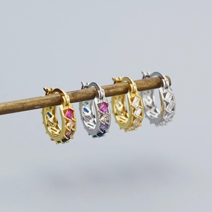 Detail of 925 silver huggie earrings with colorful zirconia stones in gold and silver