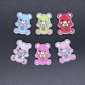Detail of colorful resin bear charms with HUG ME text for DIY phone case crafts