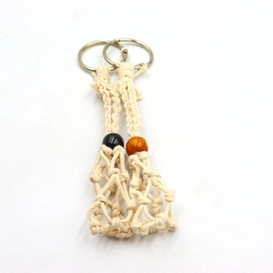 Detail of handmade woven net keychains with decorative wooden beads and metal rings