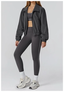 Three-piece yoga set detail showing zipper jacket, sports bra and high-waist leggings