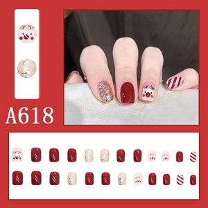Detail of A618 Christmas press-on nails featuring reindeer designs and red glitter finish