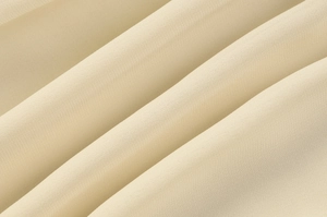 Macro shot of beige chiffon fabric detail showing soft texture and natural drapes