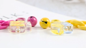 Detail view of colorful plastic butterfly clips, metal bells and chain for DIY keychains