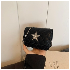 Close-up of kids black quilted bag with silver rhinestone star and metal chain strap