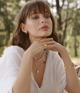 French retro style jewelry set with gold necklace, earrings and bracelet on a model