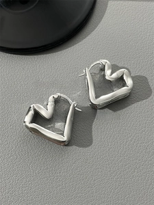 Detail shot of silver liquid heart earrings showing the S925 sterling silver stamp