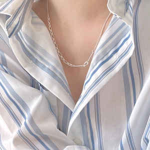 Detail of 925 sterling silver mixed chain necklace worn with a blue striped shirt