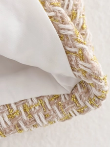 Close-up of pink and white tweed fabric with golden metallic threads and inner lining