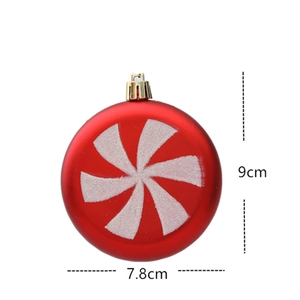 Detail of a red Christmas ornament with white swirl pattern measuring 9cm by 7.8cm