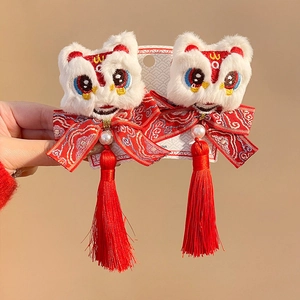 Detailed close-up of Chinese lion dance hair clips with plush texture and red tassels