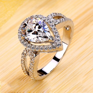 Macro detail of pear-cut halo engagement ring with double-row diamond hollow band