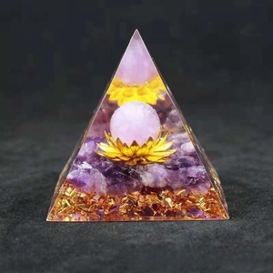 Close-up of Orgone pyramid with amethyst, pink crystal sphere and golden lotus detail