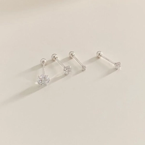 Detail view of four different sizes of 925 sterling silver zircon stud earrings in silver