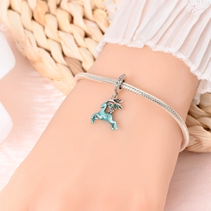Vue détaillée du pendentif cerf en argent avec pierres vertes et émail bleu sur bracelet