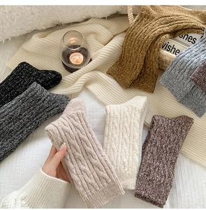 Cozy wool blend cable knit socks in multiple colors on a soft white blanket