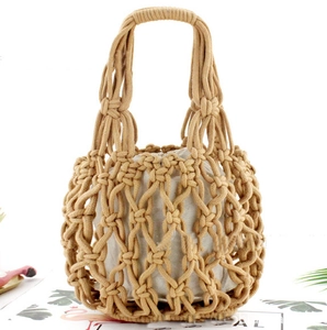 Detail of hand-woven beige cotton mesh tote bag with soft inner fabric lining and handles