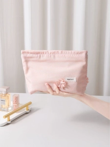 Pink checkered clover cosmetic bag with fabric flower and white H&R label handheld view