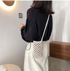 Detail of hand-woven cream cotton rope phone bag with intricate lattice pattern
