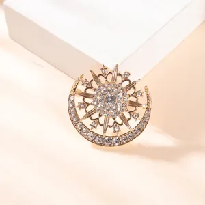 Macro detail of sun and moon alloy brooch with shimmering pavé set white rhinestones