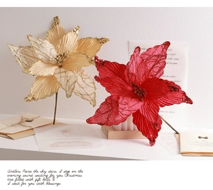 Detailed view of champagne and red artificial Christmas flowers with glitter embroidery