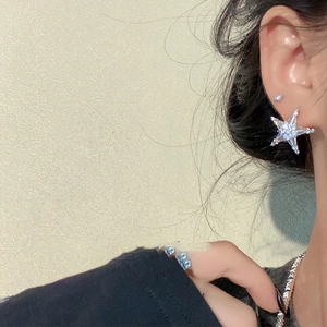 Detailed view of starfish stud earrings with sparkling cubic zirconia on a female model