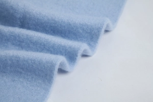 Close-up of soft light blue mohair fabric texture with delicate fuzzy fiber details