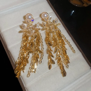 Detailed macro view of 18K gold plated flower earrings with pearl tassels and zirconias