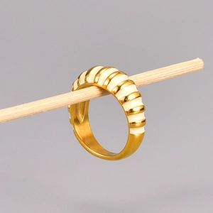 Detail of 18K gold plated croissant dome ring with cream enamel hanging on wood