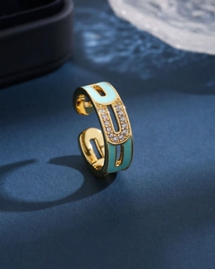 Macro shot of gold-plated open ring with blue enamel and clear zircon stones details