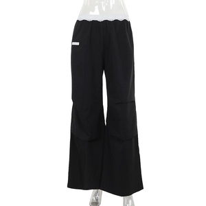 Détail du pantalon cargo avec bordure en dentelle blanche à la taille et écusson carré