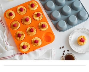Detail of 12-cup silicone muffin pans in orange and gray showing non-stick bottom texture