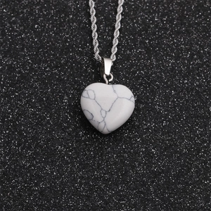 Close-up of heart-shaped white marble stone pendant with silver rope chain necklace