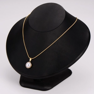 Elegant gold snake chain necklace with a pearl and diamond circular pendant on display
