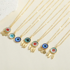 Close-up of colorful evil eye necklaces with golden heart and feather charms