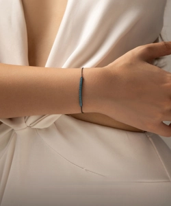 Detail shot of a vintage punk silver bracelet with turquoise gem on woman's wrist