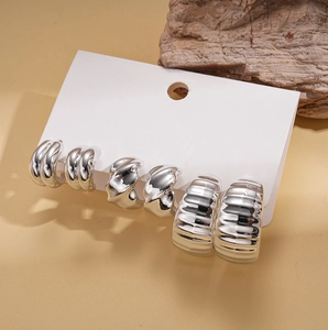 Detailed view of silver geometric C-shaped earring set with textured and smooth finishes