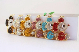 Flat lay of colorful rhinestone-studded mouse keychains in black, silver, yellow, and blue