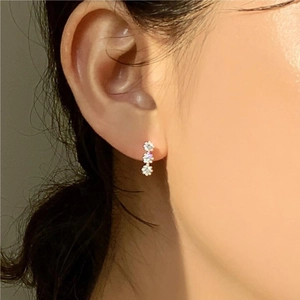 Close-up of three vertical flower clusters silver earrings with sparkling cubic zirconia