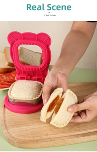 Close-up of heart-shaped crustless sandwich being opened next to the stainless steel cutter