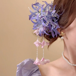 Détail de la pince à cheveux fleur de Lycoris avec glands en soie rose et perles