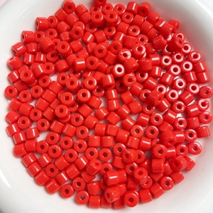 Dettaglio di perle acriliche cilindriche rosse da 6mm per creazione di gioielli fai-da-te