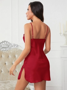 Détail d'une robe nuisette en satin rouge avec fente haute et texture soyeuse