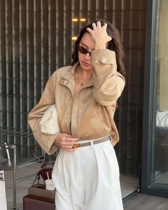 Close-up of camel suede jacket texture with white trousers and brown leather belt