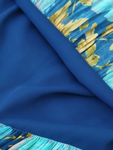 Detail of navy blue chiffon fabric with yellow floral pleated patterns and texture