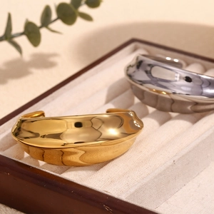 Nahaufnahme von glänzenden Edelstahl-Armreifen in Gold und Silber in einer Box