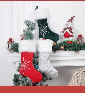 Three velvet Christmas stockings with snowflake embroidery hanging on a festive mantelpiece