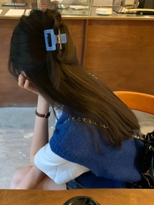 Blue square acetate hair claw clip shown in a stylish half-up hairstyle on model