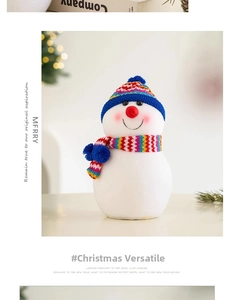 Détail d'un bonhomme de neige en peluche avec bonnet bleu et écharpe rayée colorée