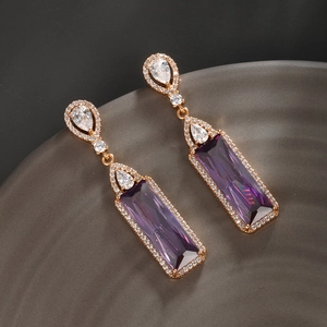 Vue macro de boucles d'oreilles géométriques en zircon violet et plaqué or