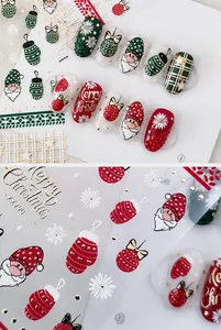 Vue macro des autocollants 3D de Noël pour ongles avec motifs Père Noël et flocons de neige